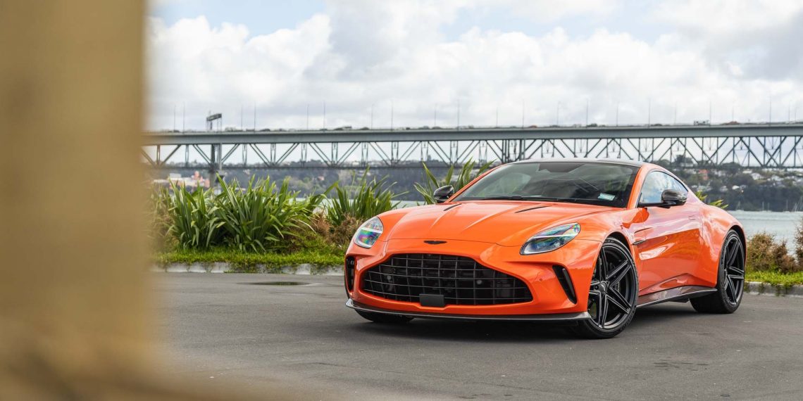 Aaston Martin Vantage 2024, in orange, parked near Auckland's Harbour bridge