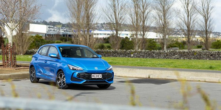 MG MG3 Hybrid Essence, parked in a carpark with trees behind, and a fence in front