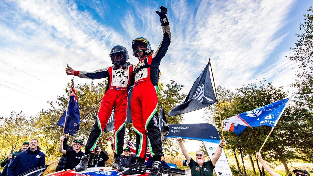 Paddon and Kennard atop their Hyundai i20 after finishing third at Rally Poland.