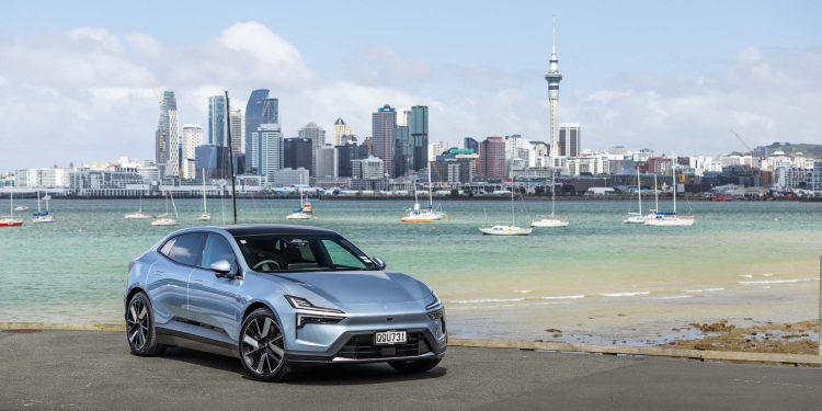 Polestar 4 Long Range dual motor, parked in front of Auckland's city scape