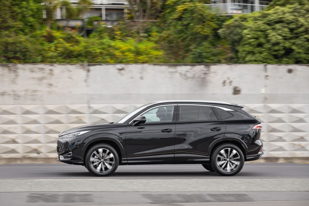 MG HS in black, side profile panning shot taken on an urban background