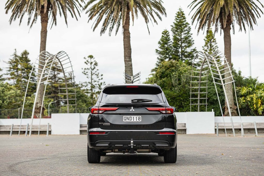 Rear shot of the 2024 Outlander Exceed 2.5, in centre of palm trees