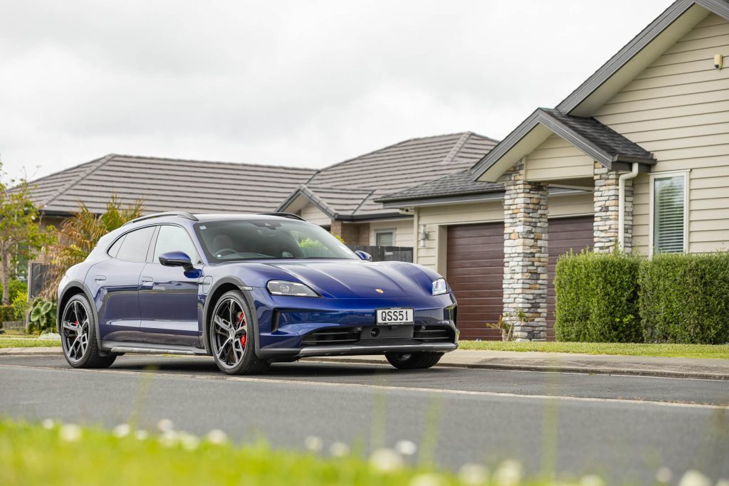 Porsche Taycan 4S Cross Turismo in blue, parked outside of a nice house.