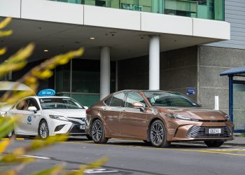 Toyota Camry Hybrid ZR in brown, parked next to an older Taxi Camry