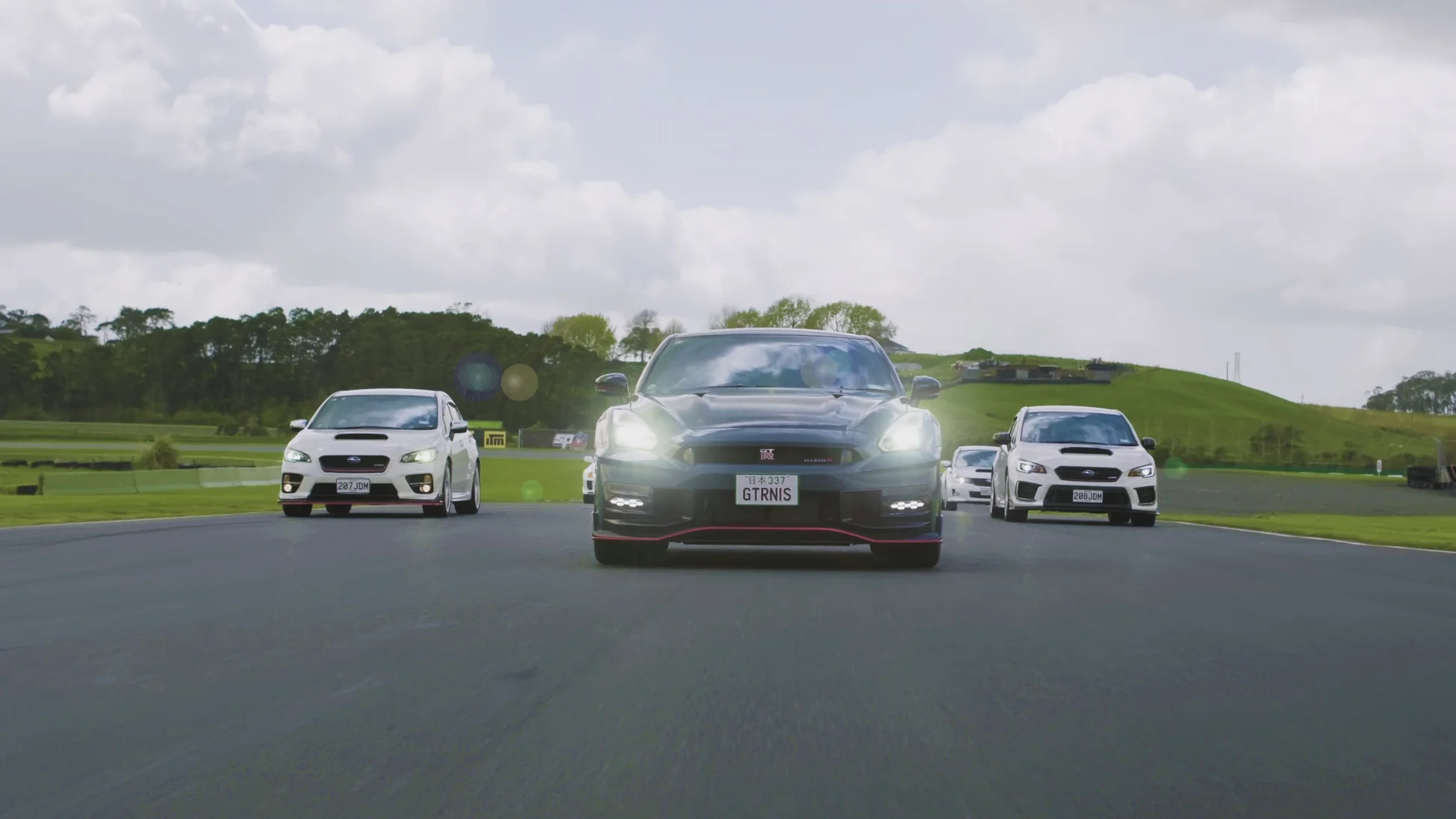 A pair of WRXs flanks the Nismo GT-R.