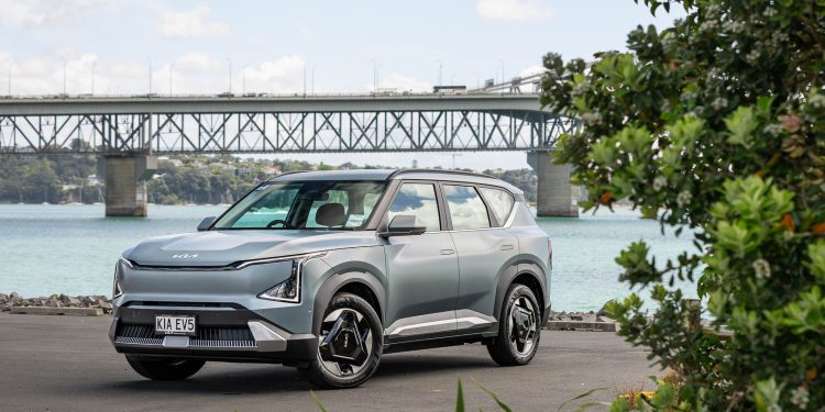 Kia EV5 light+ front quarter shot, with Auckland harbour bridge showing behind