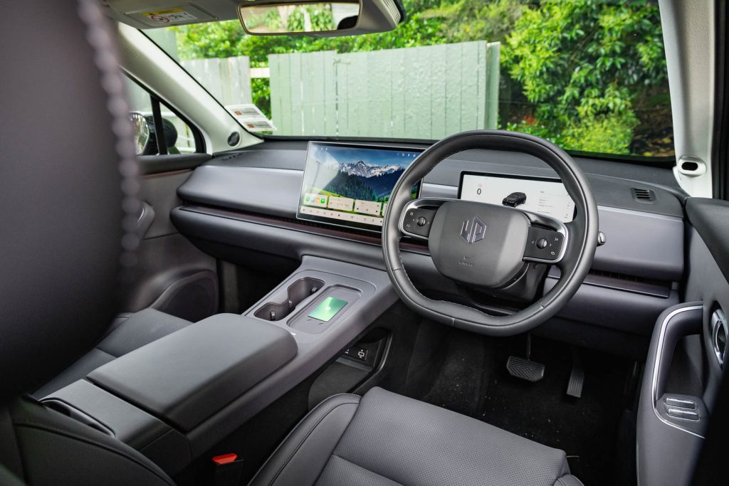 Wide front interior shot, showing charging pad, NFC key pad, steering wheel etc