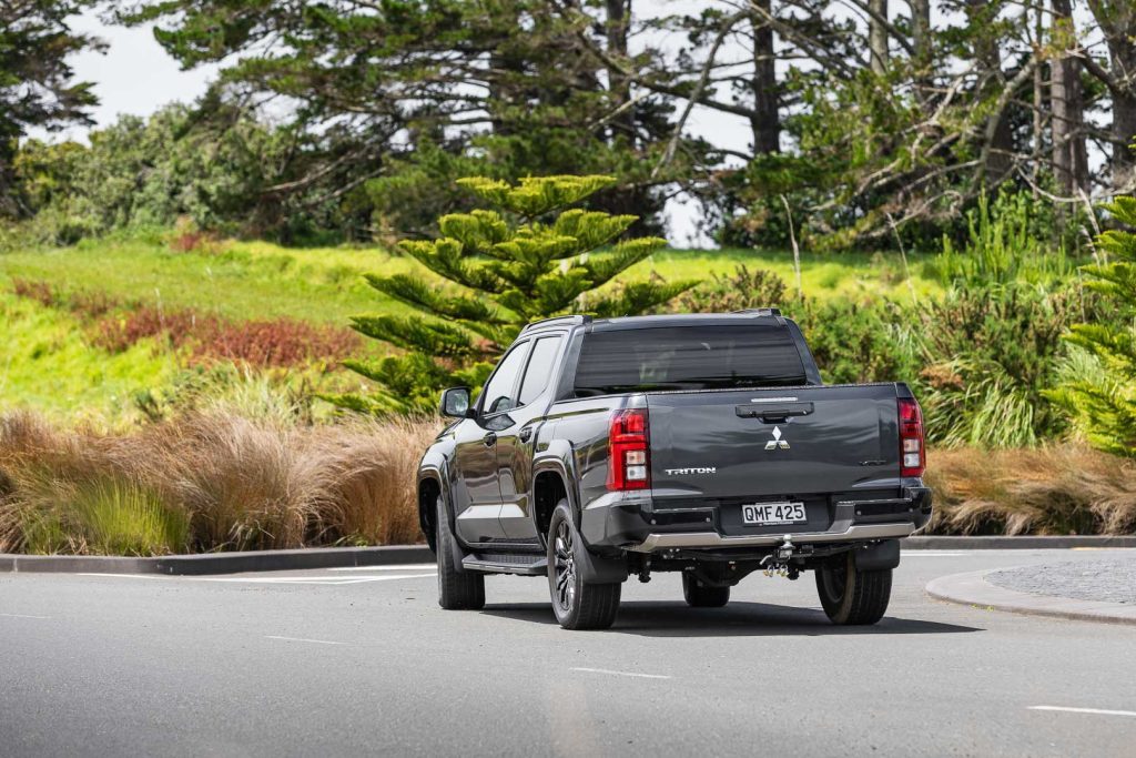 Rear end of a black 2024 Mitsubishi Triton VRX 4X4 cornering