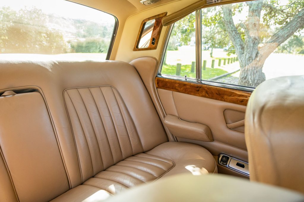 Leather rear seat space inside the 1970 Silver Shadow. Passenger mirror and pull down leather handle