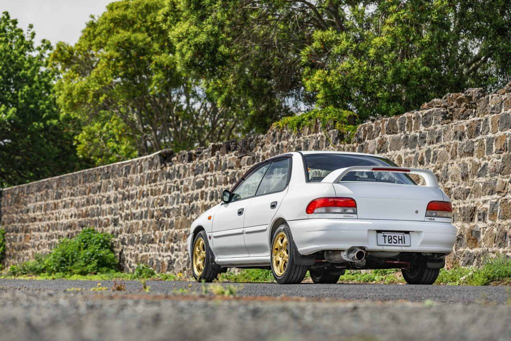 GC8 Subaru WRX STi RA in white, parked next to a fence