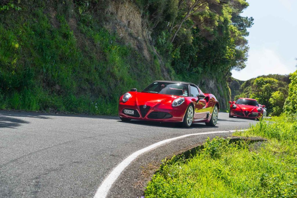 Alfa Romeo 4C going around a corner, with one behind it