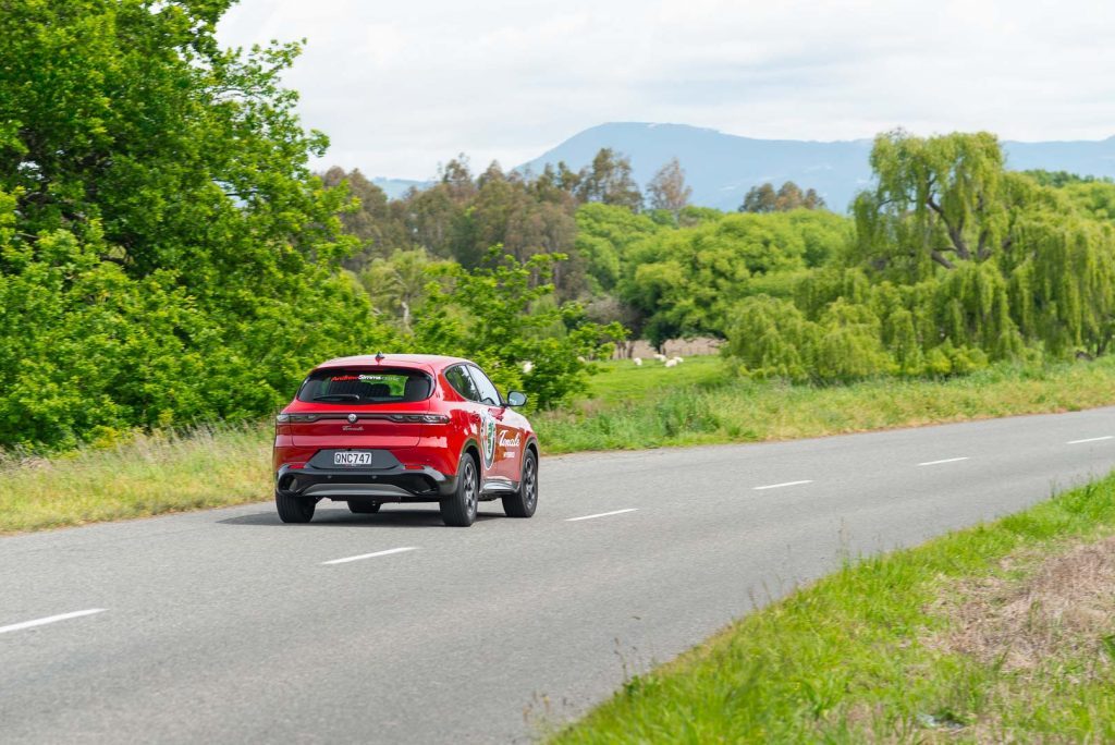 Rear driving shot of the Alfa Tonale Ti in red