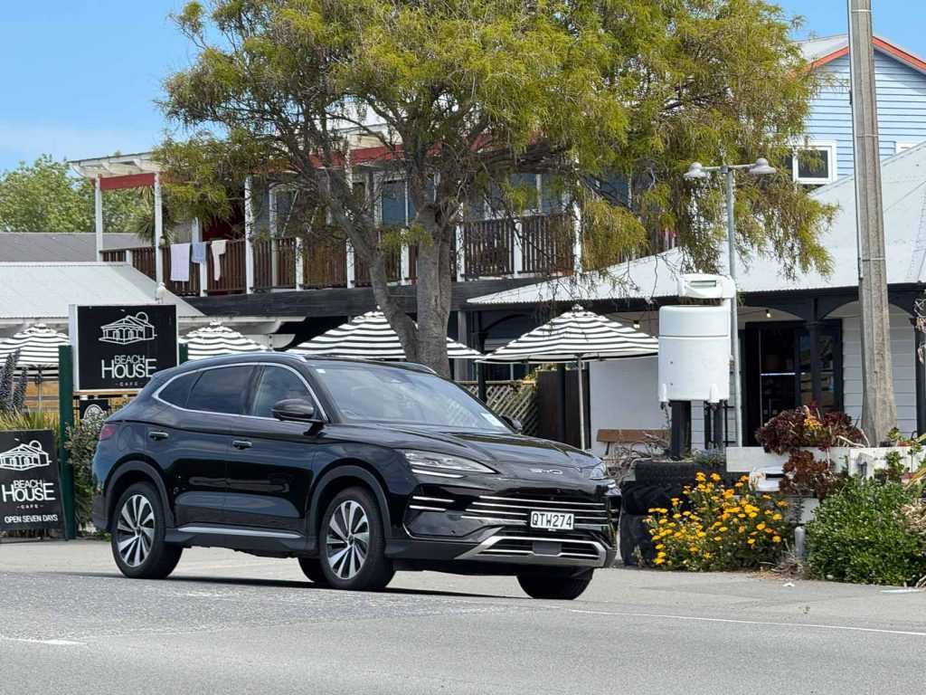 2024 BYD Sealion 6 in black, parked outside a cafe 