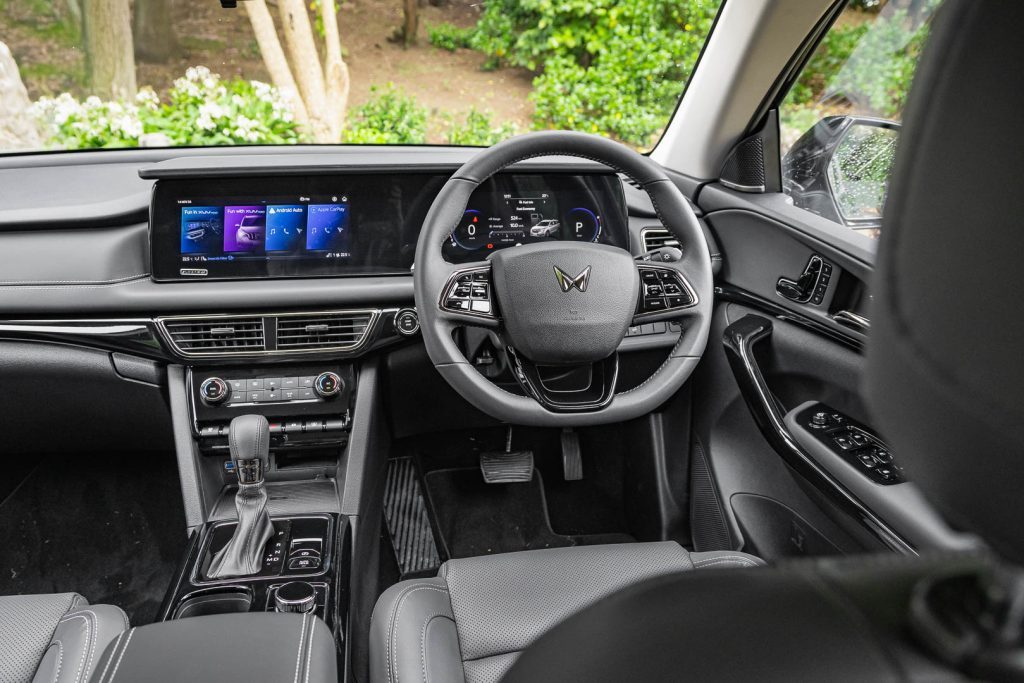 Wide front interior view of the 2024 Mahindra XUV600 AX7L, showing wheel and dash and screens