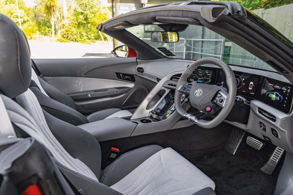 Interior of MG Cyberster featuring modern, high-tech dashboard, multi-functional steering wheel, and sleek grey and black leather seats