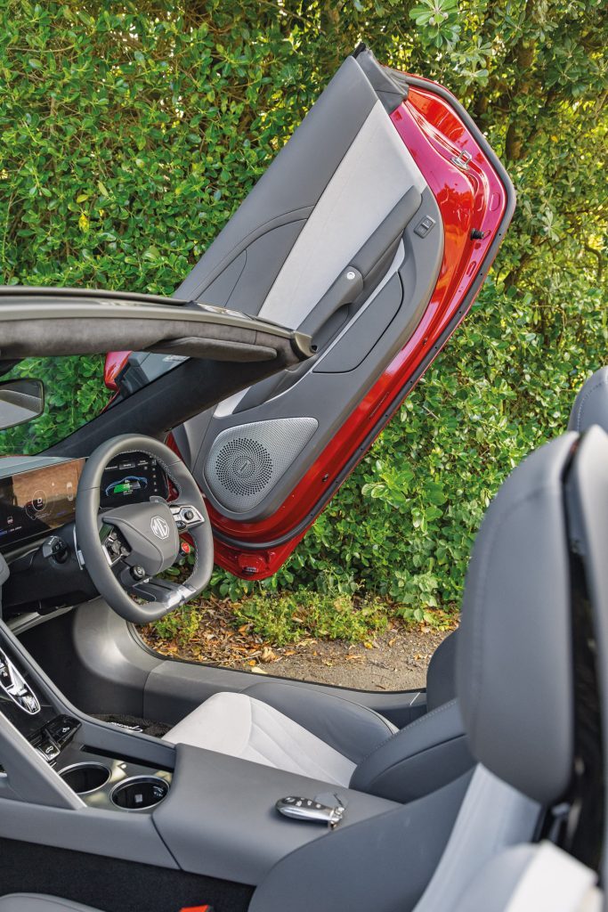 Interior of MG Cyberster showcasing red exterior doors, light grey panels, and a modern dashboard