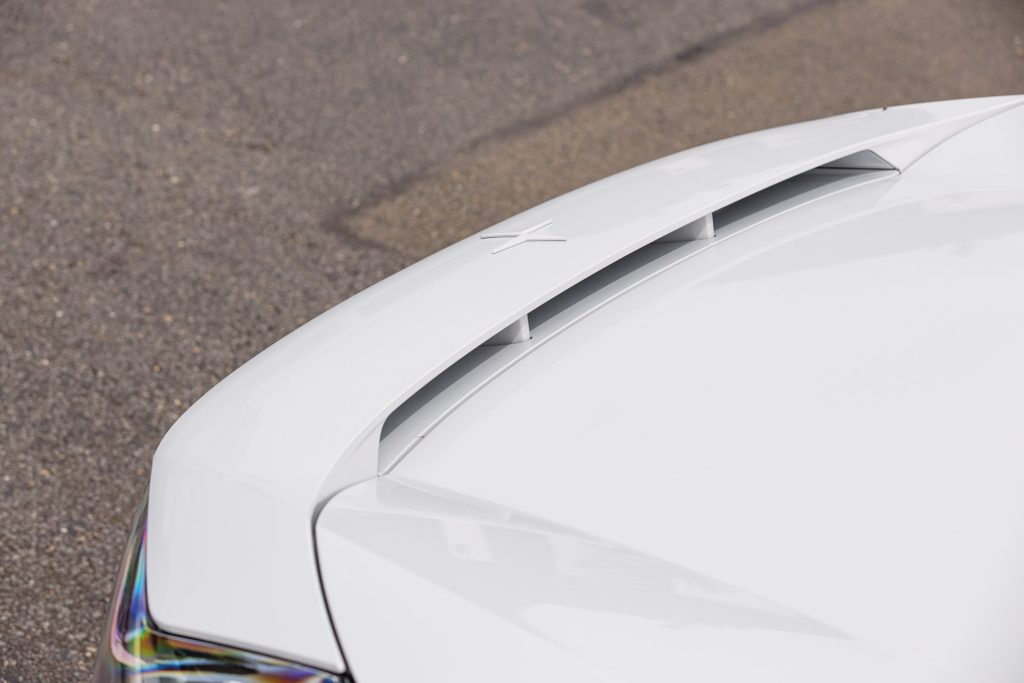 Close-up of the white Polestar 3 electric SUV's hood, showcasing the sleek design and air vents for optimized aerodynamics