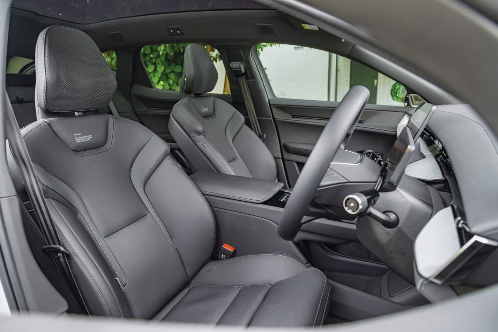 Interior of the Polestar 3 electric SUV focusing on the dark upholstered front seats with detailed stitching, sleek center console, and contemporary dashboard design