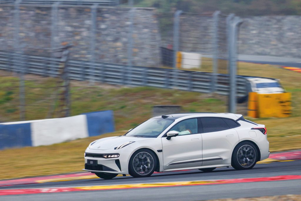 White Zeekr 001 electric vehicle driving on a racetrack