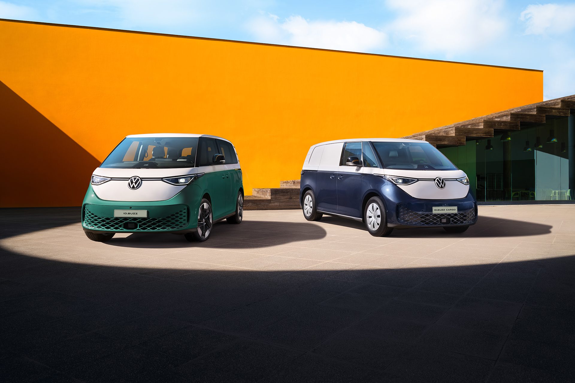 VW ID Buzz vans parked in front of an orange wall